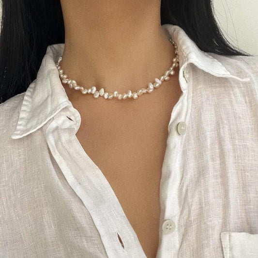 Close-up of a woman wearing an elegant natural pearl necklace with irregular freshwater pearls and a single-layer design