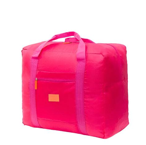 Large capacity foldable travel bag in vibrant pink with handles, displayed indoors.
