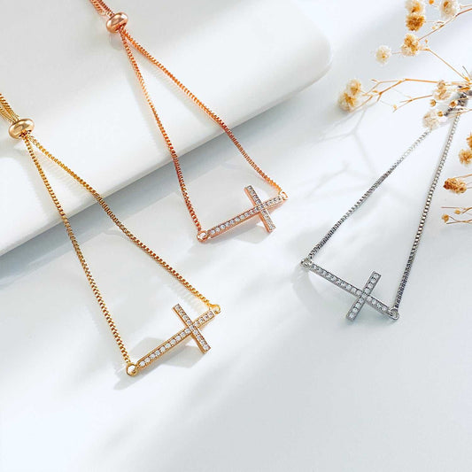 Women's diamond pull-out cross bracelets in white, gold, and rose gold with adjustable chains