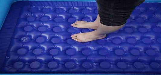 person standing on blue bubble textured bottom of baby inflatable swimming pool