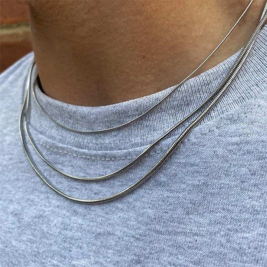 Close-up of a woman wearing a sleek women's long stainless steel necklace with layered chains and a simple design over a grey shirt