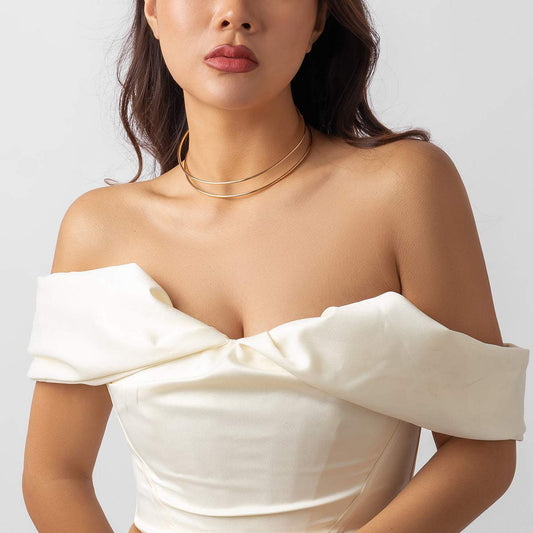 Woman wearing gold geometric open line simple clavicle chain necklace with off-shoulder white dress