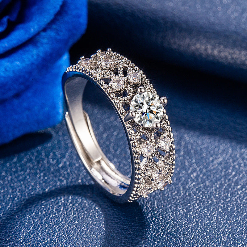 Close-up of a women's adjustable copper color moissanite ring with diamond lattice and star compass design on a dark textured surface