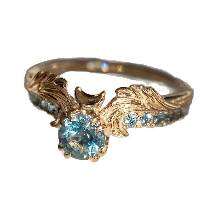 Lux Gold winged zircon ring with leaf design and blue stones Entry Lux Zircon