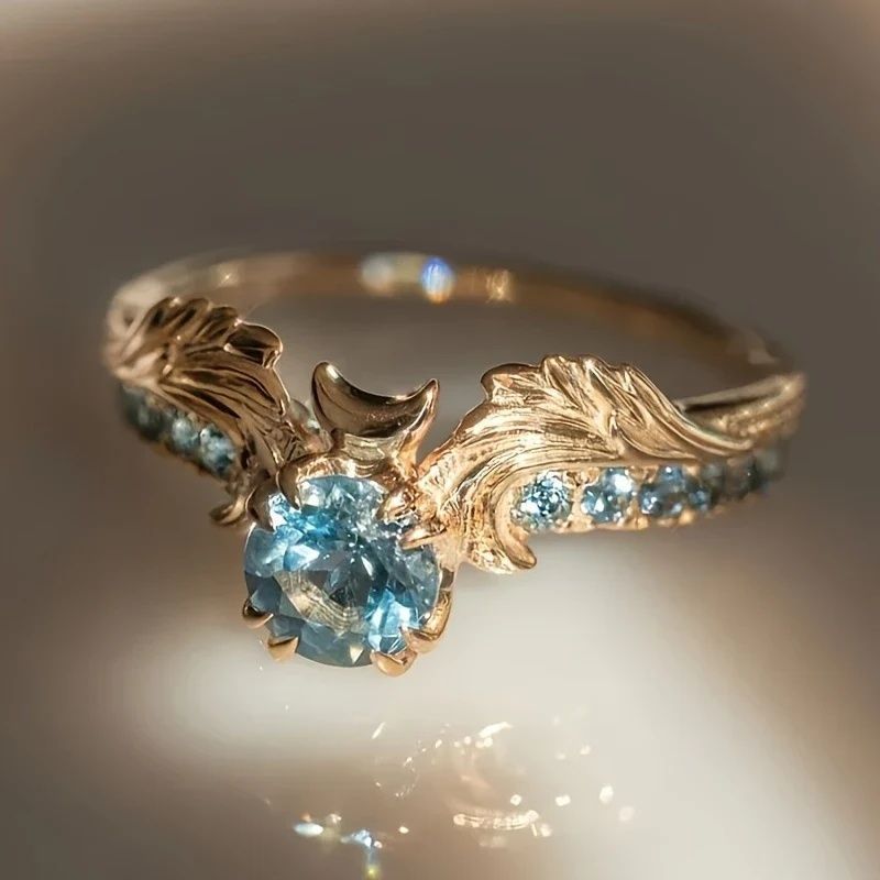 Gold Entry Lux Zircon ring with blue zircon stones and wing-shaped leaf design detail