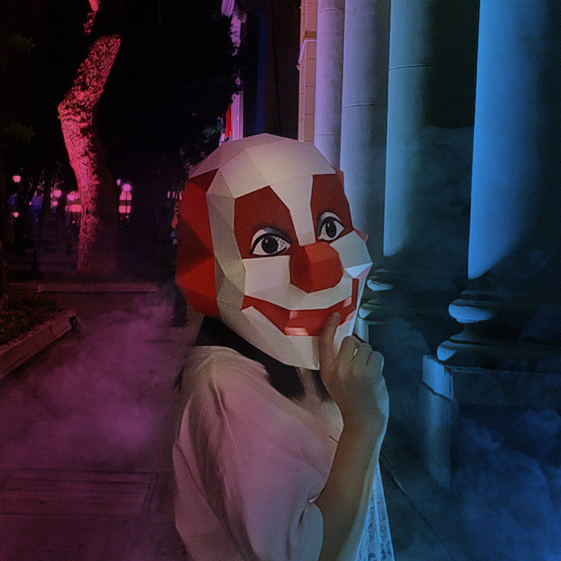A women wearing a smiling clown mask in an outdoor setting with purple lighting