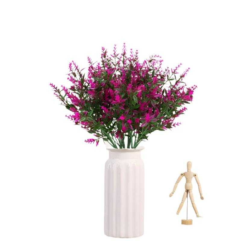 Artificial lavender flowers in white vase for home decoration.