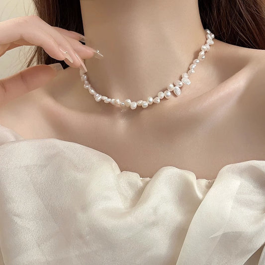 Close-up of a woman wearing an irregular freshwater natural pearl necklace with geometric-shaped pearls and a white off-shoulder top