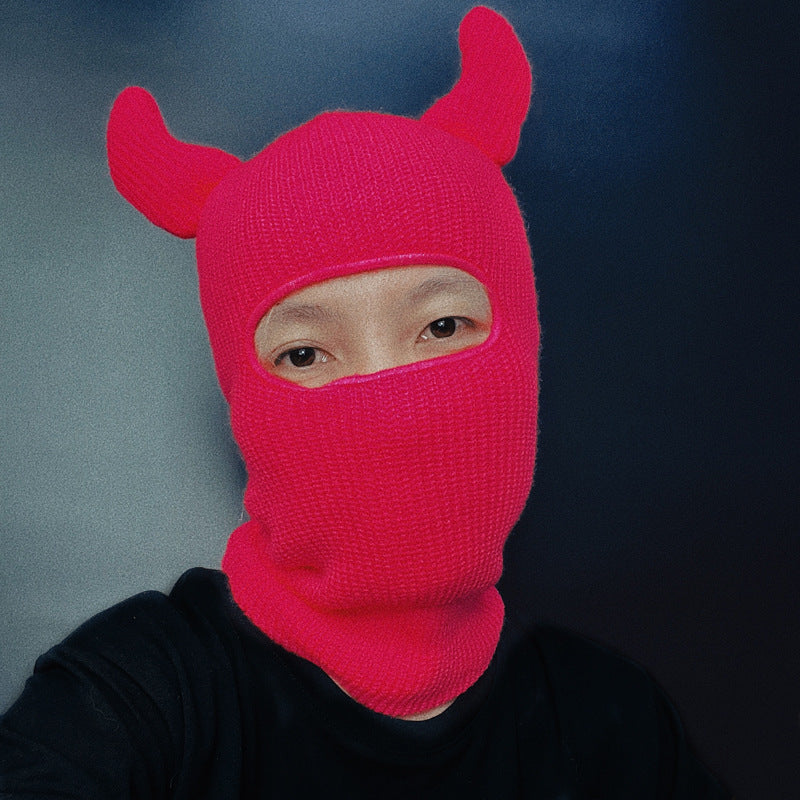 Person wearing a bright pink Horn Wool Hat with a blur background