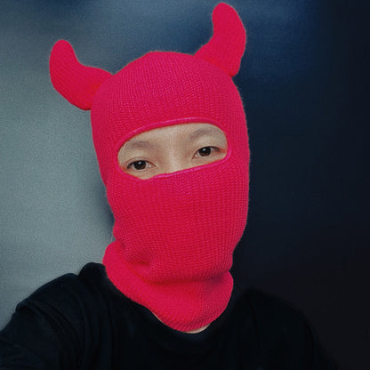 Person wearing a bright pink Horn Wool Hat with a blur background